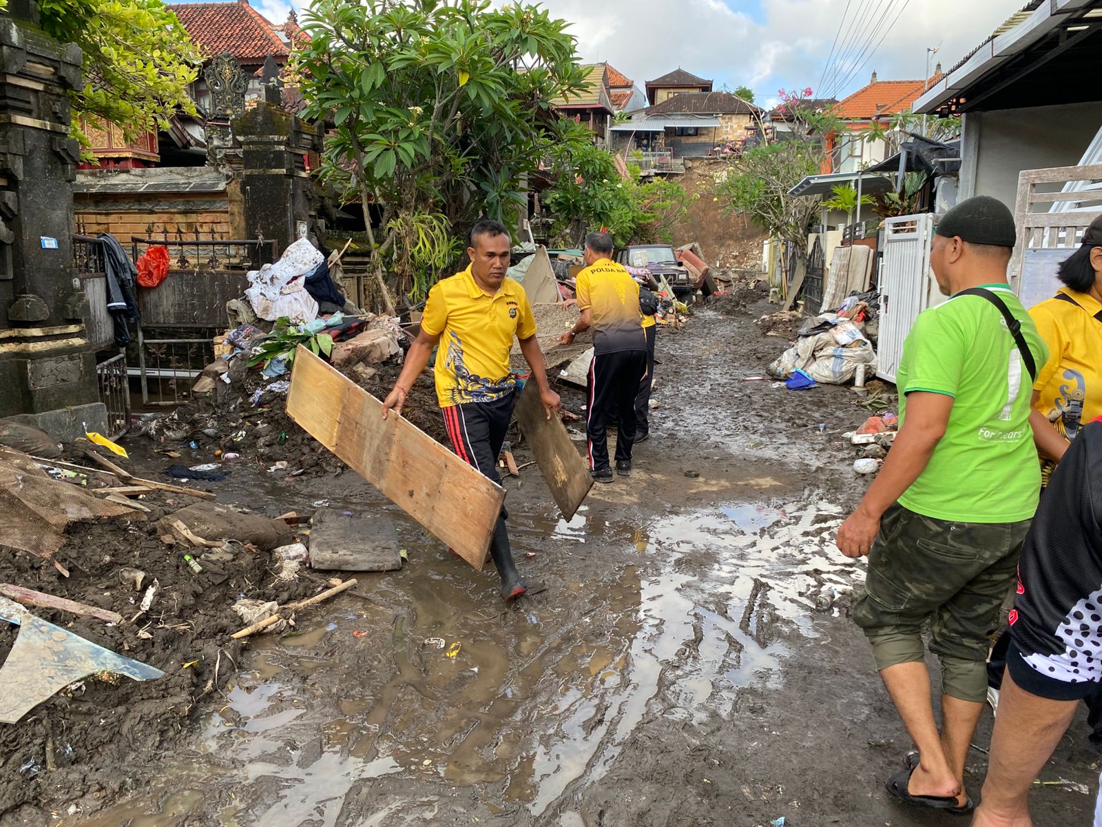 Personel Gabungan Bersihkan Material Pasca Banjir di Perumahan Kalista Ubung Kaja.
