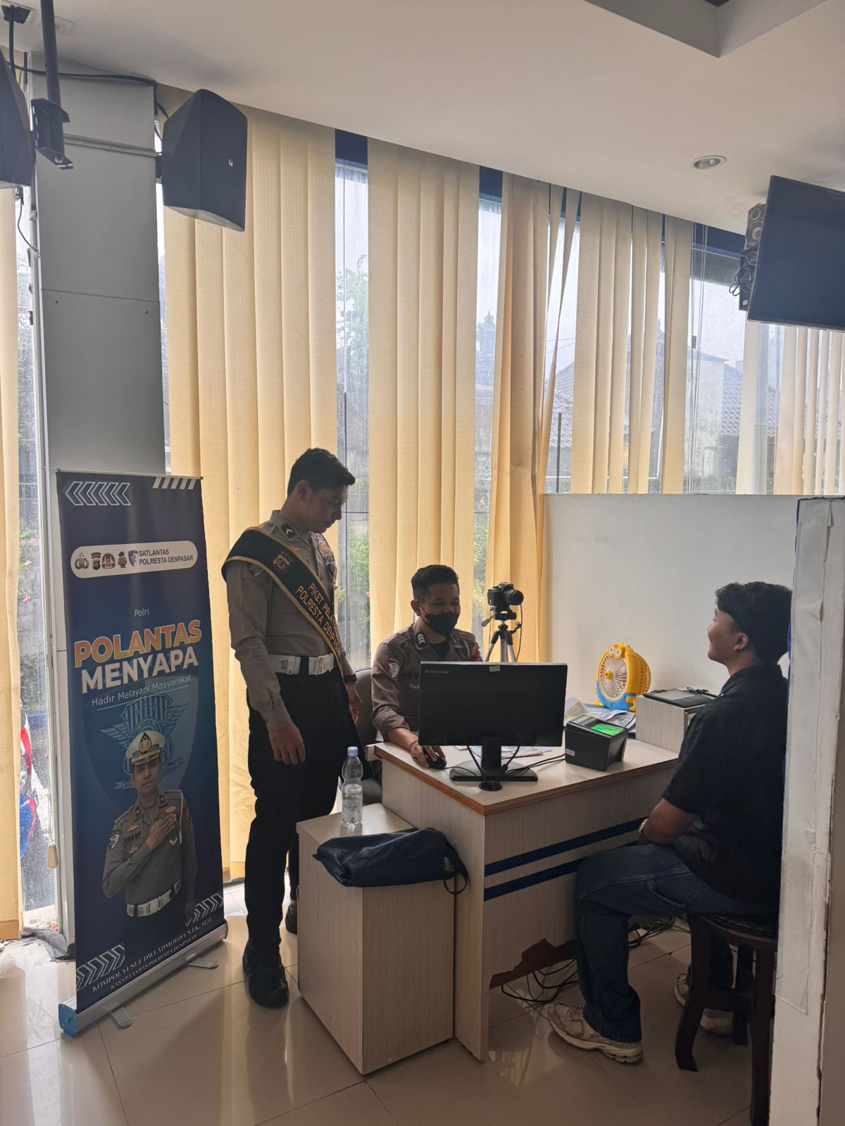 Polantas Menyapa Dampingi Pemohon SIM Saat Pendataan Identitas dan Proses Foto.